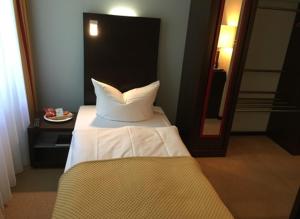 柏林戴梦赫兹酒店的一间卧室配有一张床和镜子