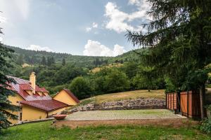 班斯卡 - 什佳夫尼察Domčok na Slnečnom Kopci的山丘上的房子,有栅栏和树木