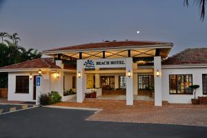 UmzumbePumula Beach Hotel的大楼前方有停车场