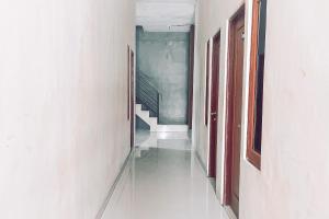 安汶Almira Homestay Ambon Mitra RedDoorz的一条空的走廊,有楼梯和楼梯间