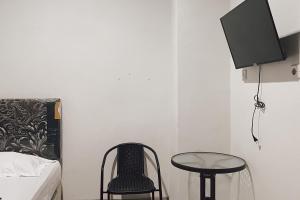 安汶Almira Homestay Ambon Mitra RedDoorz的卧室配有1张床、1张桌子和1把椅子