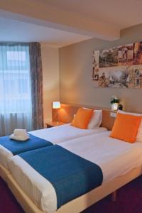 埃滕-勒尔Vincents Bed&Bistro的酒店客房带两张床,带橙色和蓝色的床单