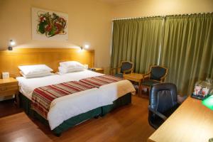 布隆方丹布隆方丹中央好酒店的酒店客房带一张大床和椅子