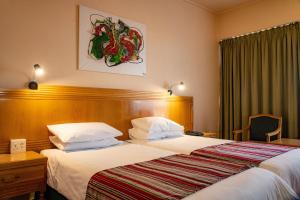 布隆方丹布隆方丹中央好酒店的酒店客房带一张大床,带白色床单