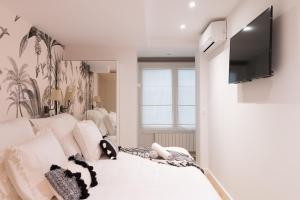 毕尔巴鄂Bilbao Art Lodge Staynnapartments的卧室配有一张白色的床,墙上配有电视