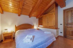 库马约尔Chalet Pontal 6的一间卧室配有一张带蓝色床单和木制天花板的床。