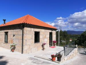 蓬德利马Casa dos Matos的一座带橙色屋顶的小石头建筑