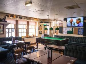 哈丁敦The Golf Tavern的一间带台球桌和电视的餐厅