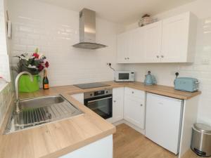 布里德灵顿Iris的厨房配有白色橱柜和水槽