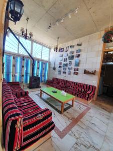 朱尼耶Damask Rose, Lebanese Guest House的一间设有红色沙发和绿色桌子的客房