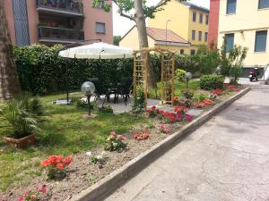 米兰花园酒店的花园设有桌子、雨伞和鲜花