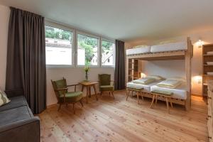 马莱斯韦诺斯塔FinKa的卧室配有两张双层床和一张桌子及椅子