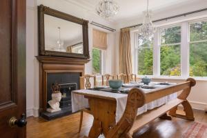 阿博因Haven Retreat Scotland - Large 4 Bed House with Woodland garden, Aboyne ,Royal Deeside的一间带桌子和壁炉的用餐室