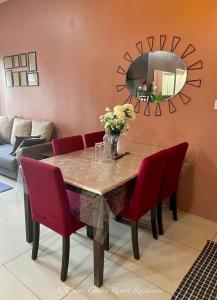 关丹KR Swiss Garden Resort Residences Kuantan的一张带红色椅子和镜子的餐桌