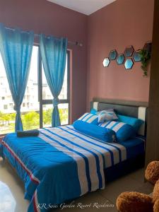 关丹KR Swiss Garden Resort Residences Kuantan的一间卧室配有一张蓝色的床和窗户
