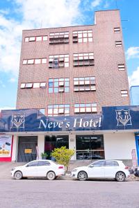 戈亚尼亚Oft Neve's hotel的停在酒店门前的两辆汽车