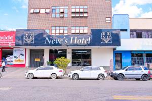 戈亚尼亚Oft Neve's hotel的三辆汽车停在酒店门前