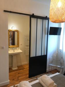 拉罗谢尔Maison Caju - La Rochelle的浴室设有黑色的门和水槽。