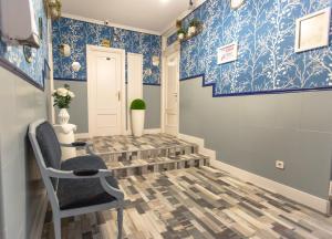 马德里Fuencarral Adeco的走廊上设有蓝色和白色的壁纸和椅子