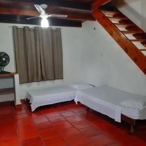 卡诺格布拉达Pousada Morada do Sol的客房设有两张床和吊扇。