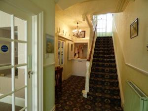 滕比Southcliff Guest House的走廊上设有通往客房的楼梯