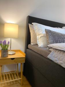 鲁塞Snow Sheep apART - апартамент с две спални的一张带枕头的床和一张带台灯的桌子