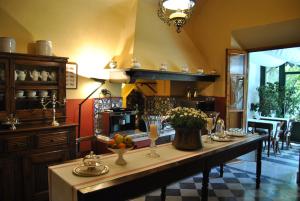 彼得拉桑塔维多米尼公寓住宿加早餐旅馆的一个大厨房,里面配有长桌子和鲜花