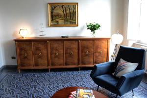 比萨Le Muse的客厅配有大型木制橱柜和椅子