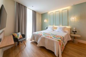 内尔哈La Puerta de Nerja BOUTIQUE - Adults Recommended的酒店客房带一张大床和一把椅子