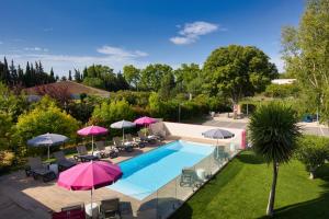 蒙彼利埃Best Western Hotelio Montpellier Sud的享有带遮阳伞的游泳池的顶部景致