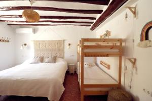 TinajerosMeravella Casa Rural的一间卧室配有一张床和一张双层床。
