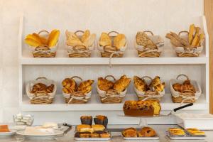 塞亚LOBOS VILLAGE - Alojamento的架子上放着一捆面包篮和糕点