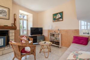 阿罗芒什莱班Maison avec beau jardin - Centre ville d'Arromanches的带沙发和电视的客厅