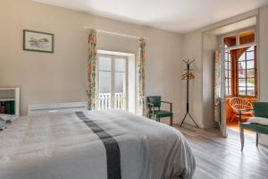 阿罗芒什莱班Maison avec beau jardin - Centre ville d'Arromanches的一间卧室配有一张大床和椅子
