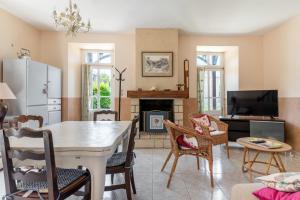 阿罗芒什莱班Maison avec beau jardin - Centre ville d'Arromanches的客厅配有桌子和壁炉