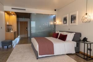 塞亚LOBOS VILLAGE - Alojamento的一间卧室设有一张大床和一个步入式淋浴间。