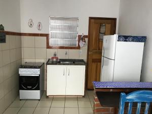 塞拉Casa quadra praia Jacaraipe的厨房配有白色冰箱和水槽