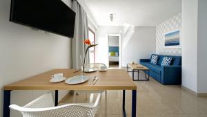 卡勒达德福斯特Broncemar Beach Suites的客厅配有桌子和蓝色沙发