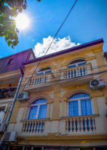 比托拉Good Times Luxury Apartments Bitola的黄色的建筑,设有窗户和阳台