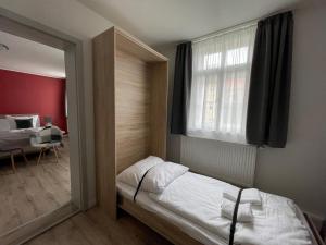 魏玛阿尔茨塔德旅馆的一间小卧室,配有床和窗户