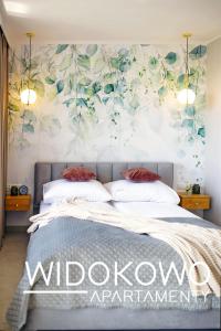 厄尔科WIDOKOWO Apartamenty的卧室配有一张带花卉壁画的床。