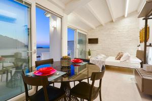 卡斯泰拉马莱Porta del Golfo Apartments & Suites的用餐室以及带桌椅的起居室。