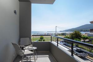斯塔夫罗斯Allonda Seafront Experience的阳台配有两把椅子,享有海滩美景
