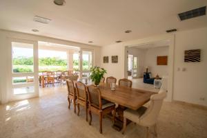 蓬塔卡纳Golf-front villa with large spaces, staff and pool, situated in luxury beach resort的一间带木桌和椅子的用餐室