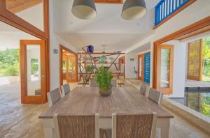 蓬塔卡纳Amazing 4-bedroom tropical villa with private pool and golf course view at luxury resort的一间带木桌和椅子的用餐室