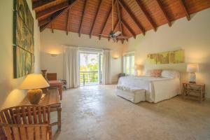 蓬塔卡纳Spacious lake front villa with in-room jacuzzis in luxury golf and beach resort的卧室设有白色的床和木制天花板。