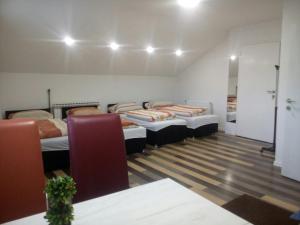 萨拉热窝库姆瑞亚桥住宿酒店的带三张床的房间和一个带椅子的房间