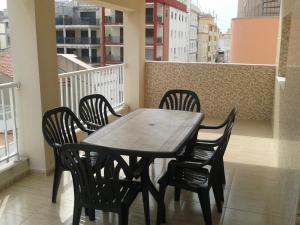 贝利雷瓜尔德Apartamento junto al mar的阳台上的木桌和椅子