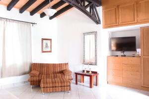 多洛雷斯-伊达尔戈La Capilla Hotel的客厅配有椅子和平面电视