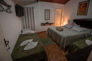 康赛瓦托利亚Hotel Fazenda Monteiro的酒店客房设有两张床和电视。